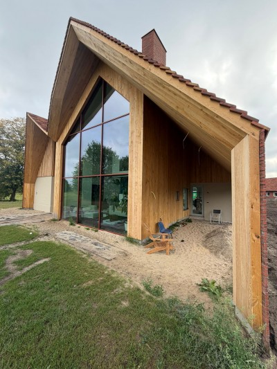 Moderne tweekapsboerderij van Warmes in het buitengebied van Rossum met handgemaakte dakpannen van Petersen Tegl, bijna voltooid.